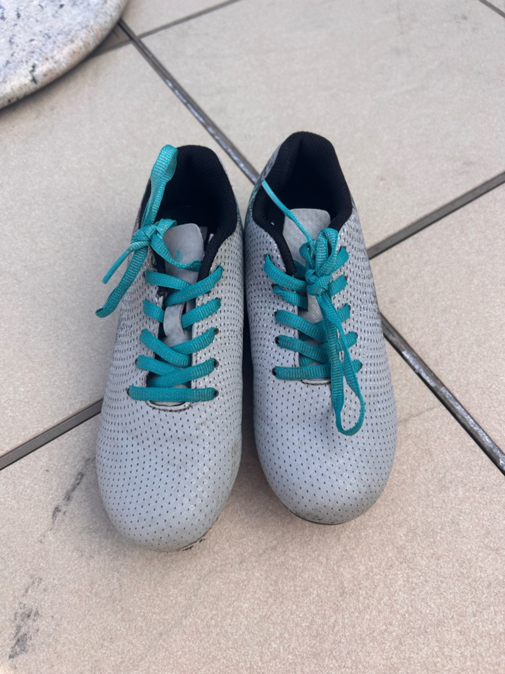 Light gray and teal soccer cleats